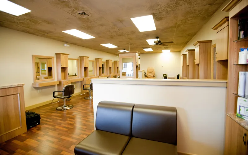 The salon seen from the entrance, looking past the reception counter towards the styling stations.